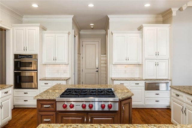 kitchen featuring decorative backsplash, white cabinetry, dark hardwood / wood-style flooring, and stainless steel appliances