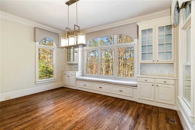 unfurnished dining area featuring dark hardwood / wood-style floors and crown molding