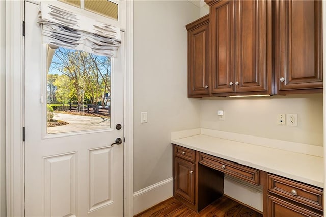 interior space featuring dark hardwood / wood-style flooring and built in desk