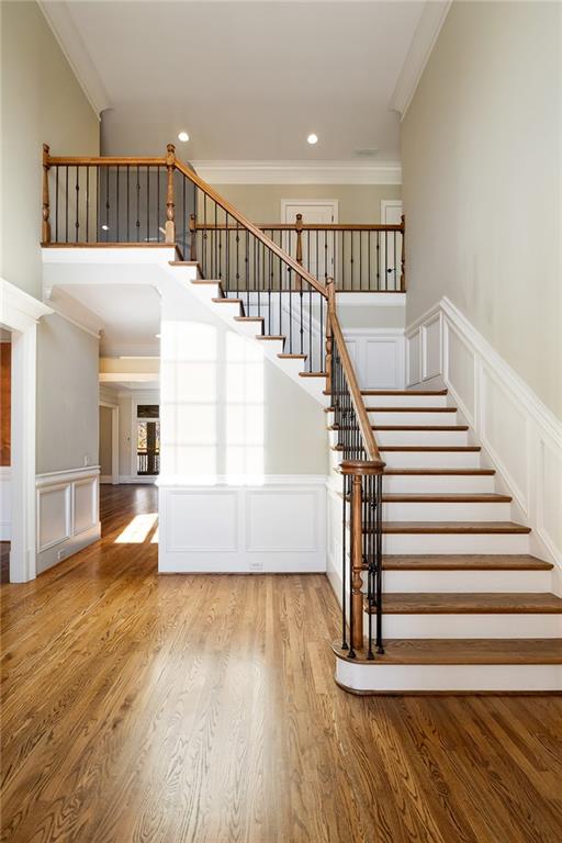 staircase featuring hardwood / wood-style flooring and ornamental molding