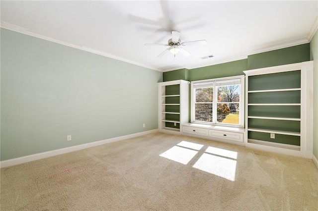 carpeted empty room with ceiling fan and crown molding