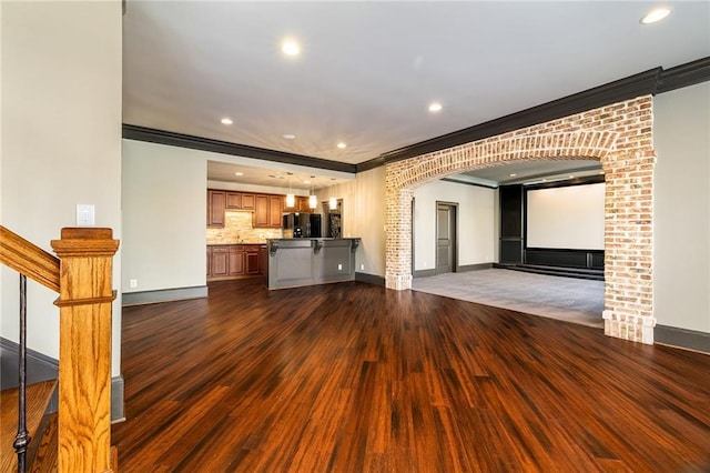 unfurnished living room with dark hardwood / wood-style floors and ornamental molding