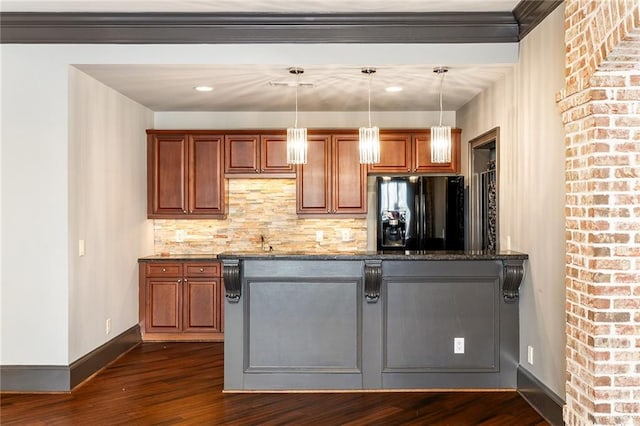 kitchen with decorative light fixtures, dark hardwood / wood-style floors, black refrigerator with ice dispenser, and dark stone counters