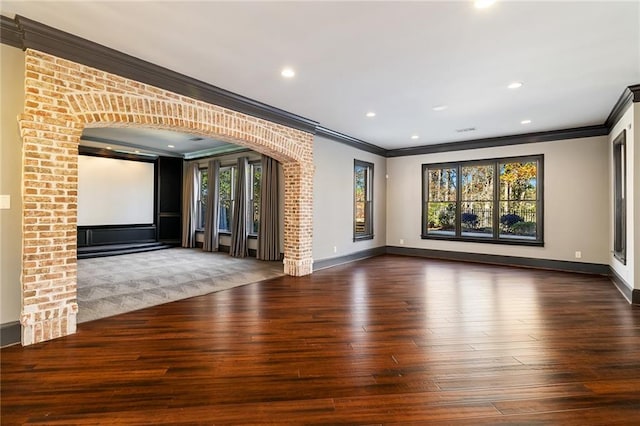 interior space with dark hardwood / wood-style flooring, crown molding, and a wealth of natural light