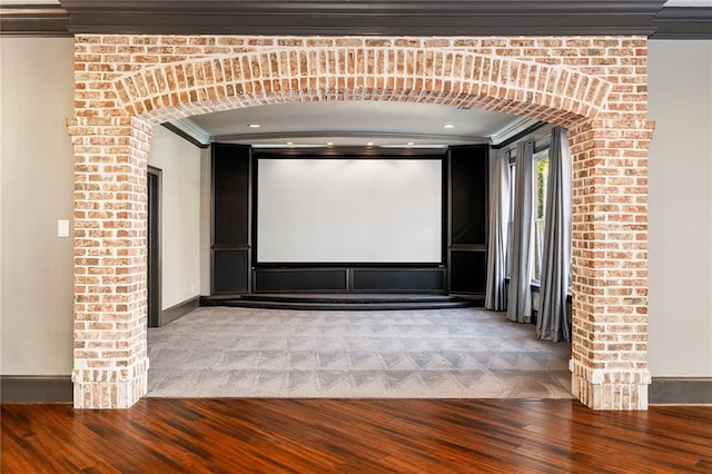 cinema room with wood-type flooring and ornamental molding