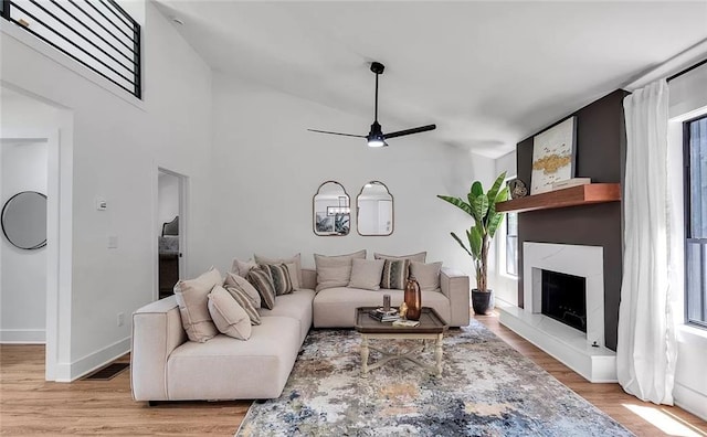 living room with ceiling fan, a healthy amount of sunlight, light hardwood / wood-style floors, and vaulted ceiling