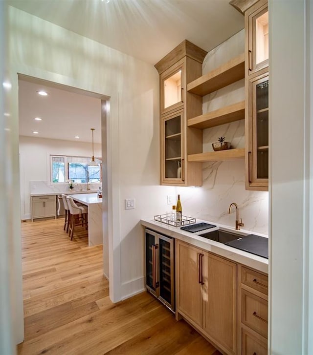 kitchen featuring light countertops, wine cooler, and light wood finished floors