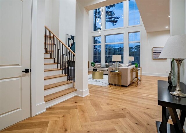 interior space with recessed lighting, baseboards, and a towering ceiling