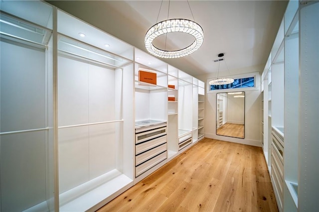 walk in closet with light wood finished floors