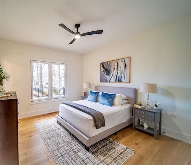 bedroom with a ceiling fan, baseboards, and light wood-type flooring