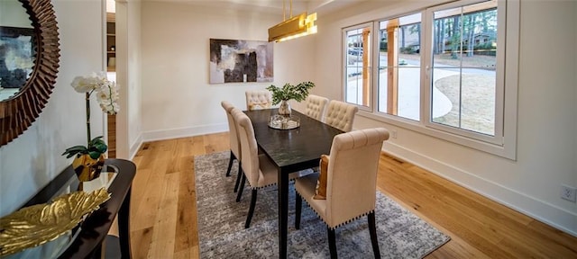 dining area with plenty of natural light, wood finished floors, and baseboards