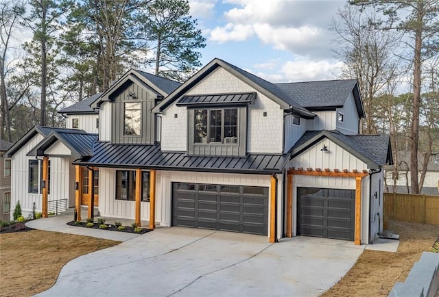 modern farmhouse style home featuring driveway, fence, a standing seam roof, and board and batten siding