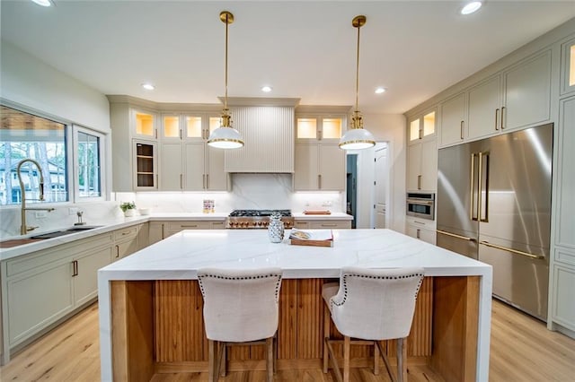 kitchen featuring a sink, decorative backsplash, a center island, and stainless steel appliances