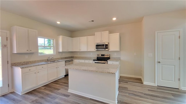 5110 Black Bear Trl, Douglasville, GA 30135 - kitchen with appliances with stainless steel finishes, a sink, light wood-type flooring, white cabinetry, and recessed lighting