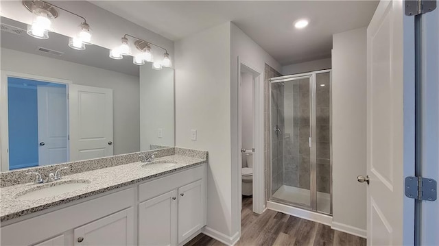 5110 Black Bear Trl, Douglasville, GA 30135 - full bath featuring wood finished floors, a stall shower, toilet, double vanity, and baseboards