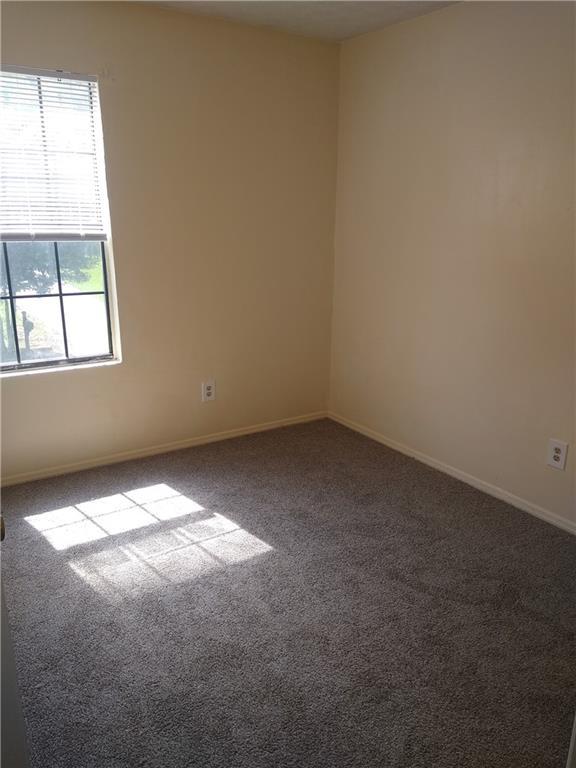 carpeted spare room with baseboards