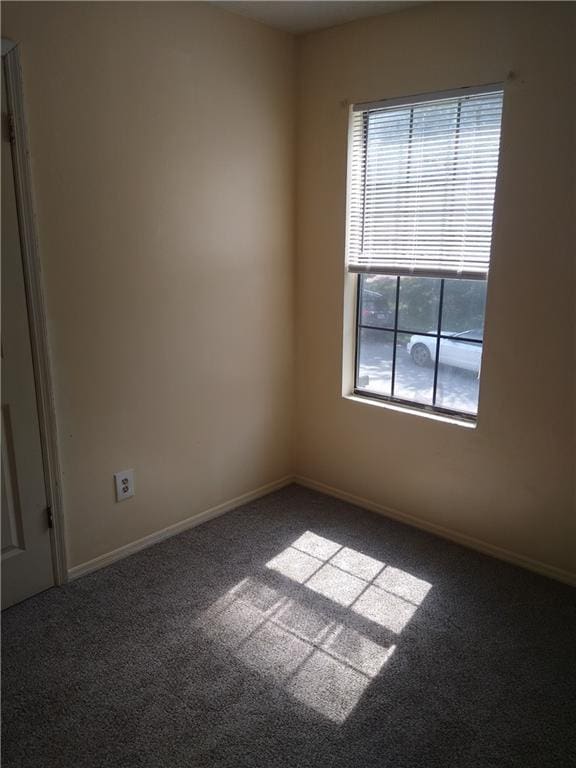 unfurnished room with carpet flooring, a healthy amount of sunlight, and baseboards