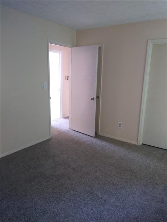 carpeted empty room with baseboards