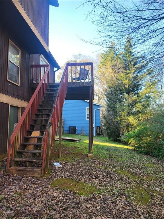 exterior space with stairs, central air condition unit, and a wooden deck