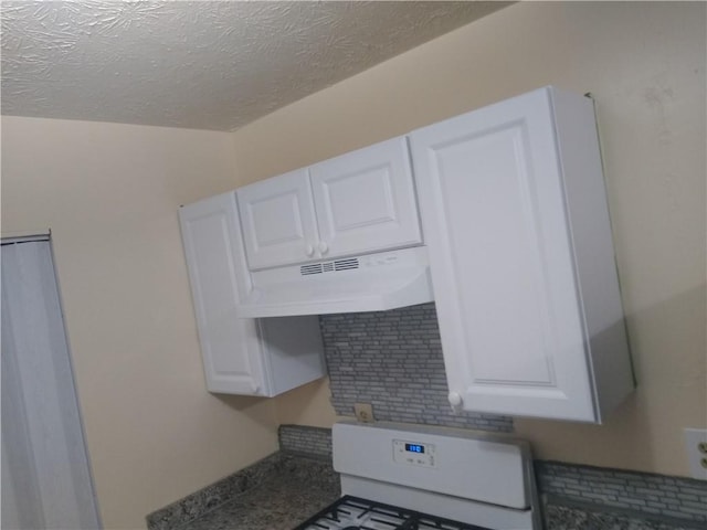 interior details with range with gas cooktop, white cabinets, under cabinet range hood, and a textured ceiling