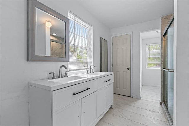 full bathroom with a shower with shower door, double vanity, a sink, and marble finish floor