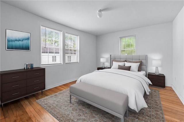 bedroom featuring light wood-style floors and baseboards
