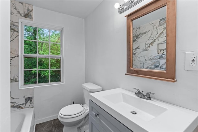 full bathroom featuring a tub, vanity, baseboards, toilet, and marble finish floor