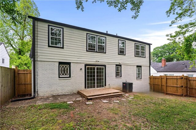 back of property featuring brick siding, a fenced backyard, and cooling unit