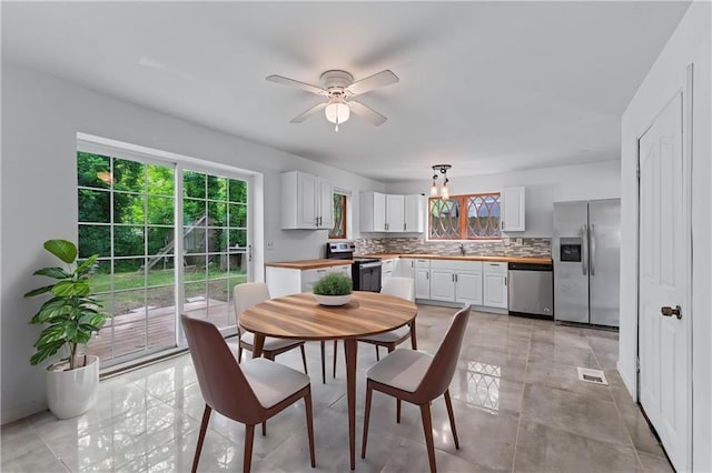 dining room featuring baseboards, ceiling fan with notable chandelier, and visible vents