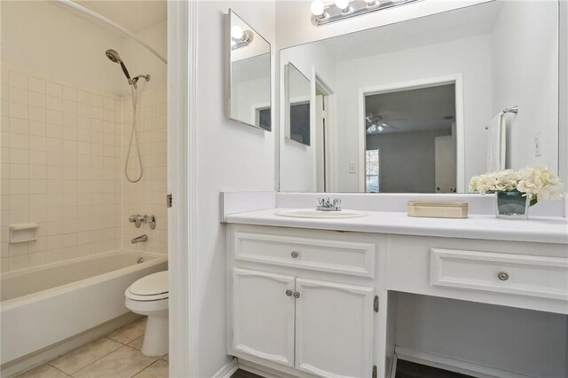 full bathroom featuring vanity, tile patterned floors, toilet, and tiled shower / bath