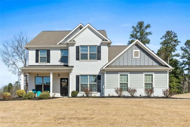 craftsman inspired home with brick siding, board and batten siding, and a front yard