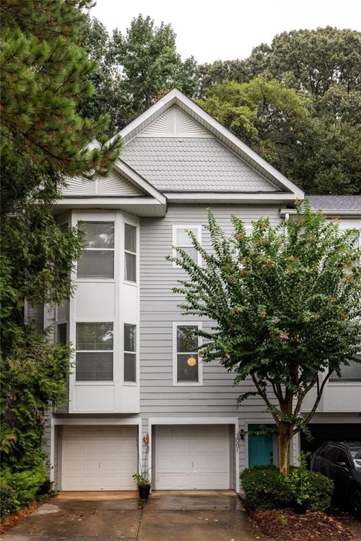 view of side of home featuring a garage and concrete driveway