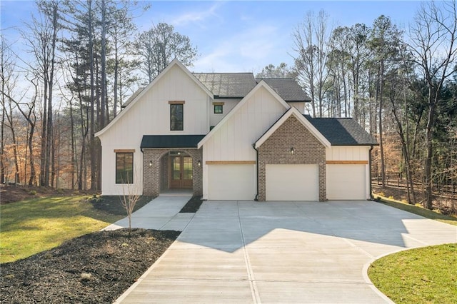 modern farmhouse featuring a front yard and a garage