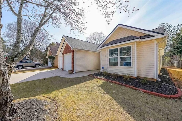 view of side of property with an outbuilding, driveway, a yard, a garage, and brick siding