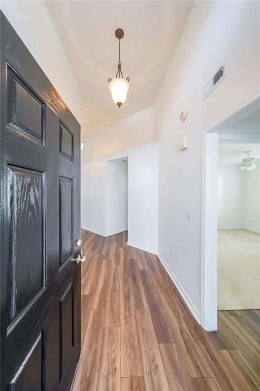 foyer with baseboards, visible vents, and light wood-type flooring