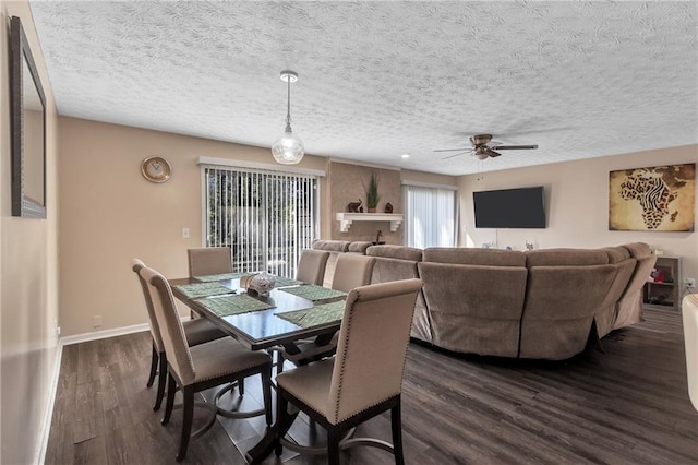 dining space with a textured ceiling, a ceiling fan, baseboards, and dark wood-style flooring