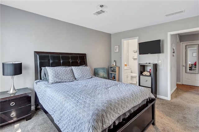 bedroom with visible vents, carpet flooring, ensuite bath, and baseboards