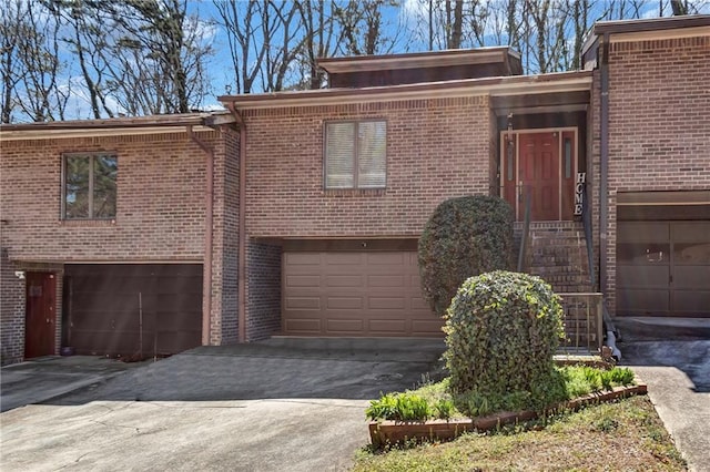 view of front of property featuring a garage, brick siding, and driveway