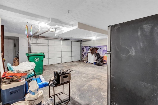 garage featuring a garage door opener and freestanding refrigerator