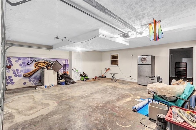 garage featuring a garage door opener and freestanding refrigerator