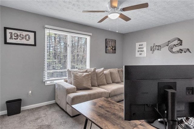 carpeted living room with baseboards, a textured ceiling, and ceiling fan