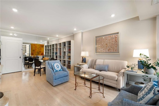 living room with crown molding and light hardwood / wood-style flooring