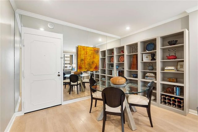 dining area featuring crown molding and light hardwood / wood-style flooring