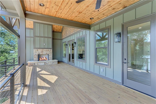 wooden terrace with ceiling fan and a fireplace