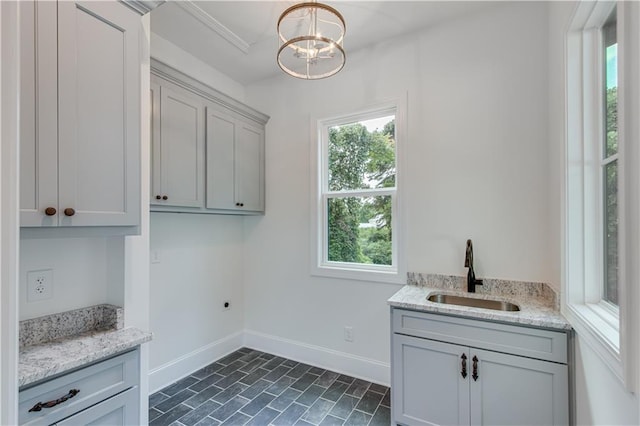 laundry room with electric dryer hookup, a chandelier, a healthy amount of sunlight, and sink