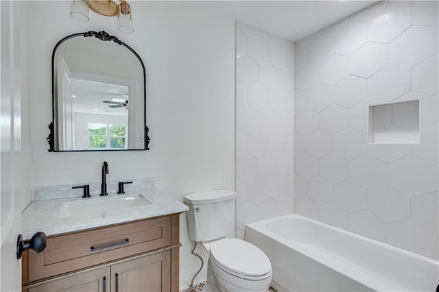 full bathroom featuring toilet, tiled shower / bath, ceiling fan, and vanity