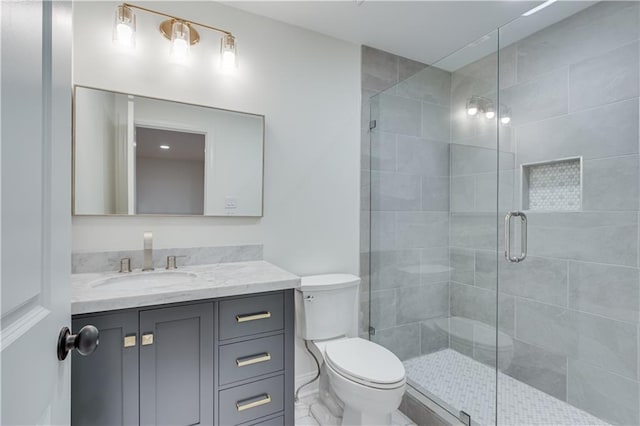 bathroom featuring toilet, an enclosed shower, and vanity