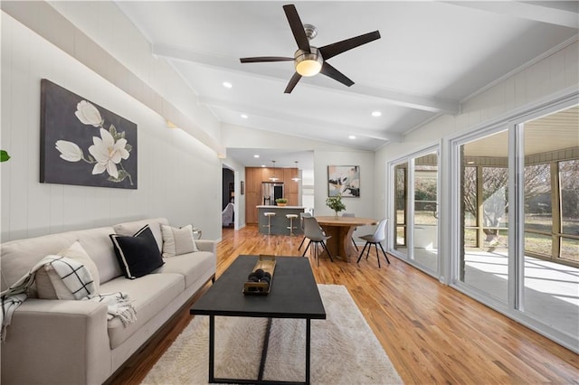 living room featuring lofted ceiling with beams, ceiling fan, and light hardwood / wood-style floors