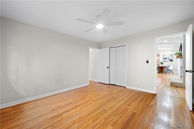 unfurnished bedroom featuring light hardwood / wood-style floors, a closet, and ceiling fan