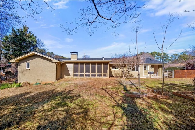 rear view of house featuring a sunroom and a yard